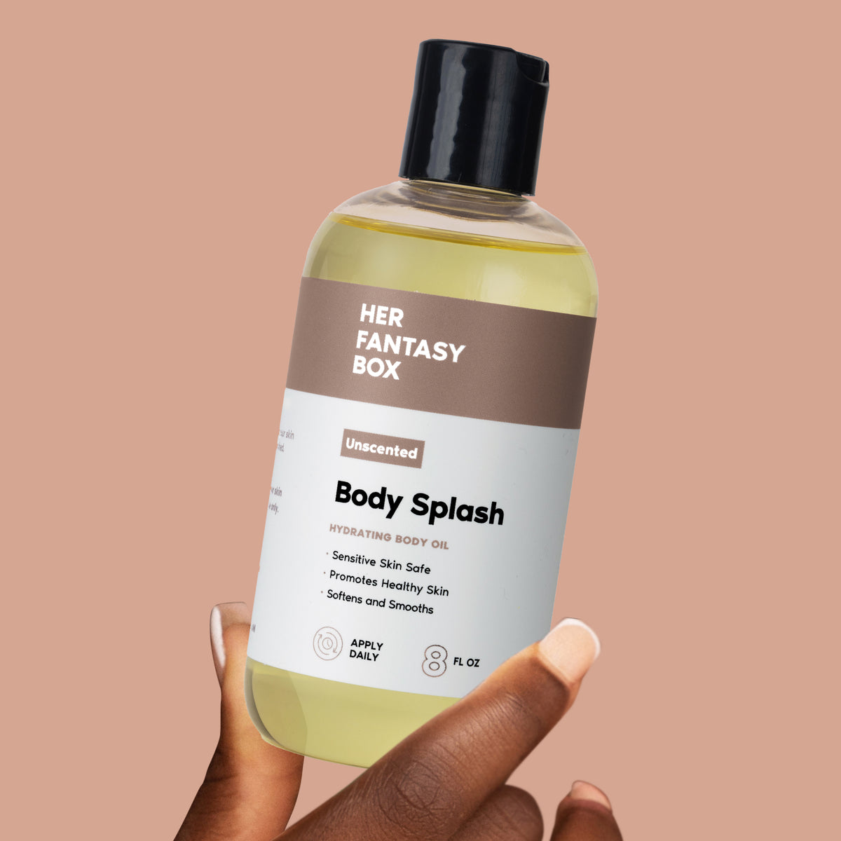 Hand holding Her Fantasy Box Unscented Body Splash sensitive skin-safe hydrating body oil against blush background