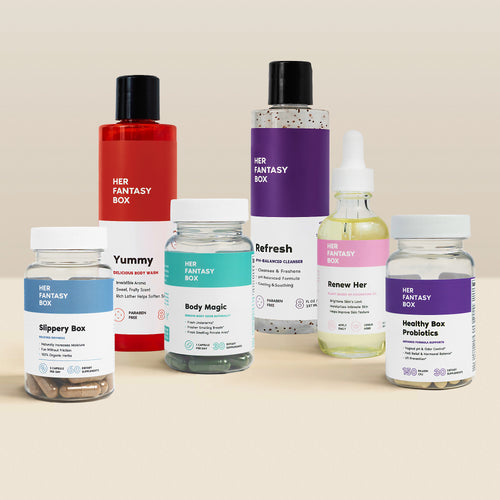 Her Fantasy Box product collection including Slippery Box, Yummy body wash, Body Magic, Refresh cleanser, Renew Her oil, and Healthy Box Probiotics on a beige background.