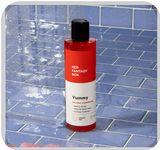 Her Fantasy Box Yummy full body cleansing gel on blue tile shower surface — stress relief and full body freshness