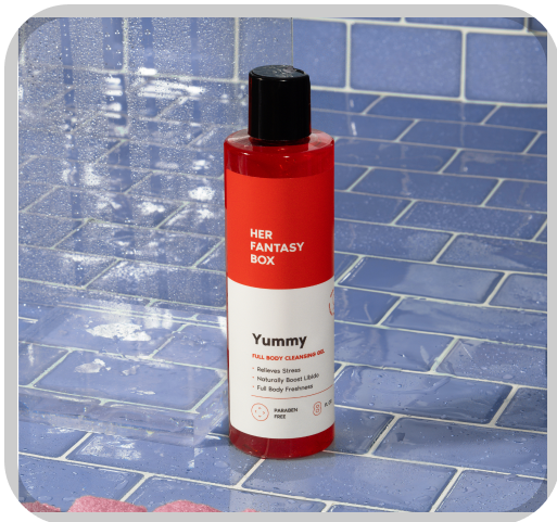 Her Fantasy Box Yummy full body cleansing gel on blue tile shower surface — stress relief and full body freshness