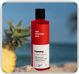 Her Fantasy Box Yummy full body cleansing gel on a sandy beach with a pineapple — libido-boosting formula