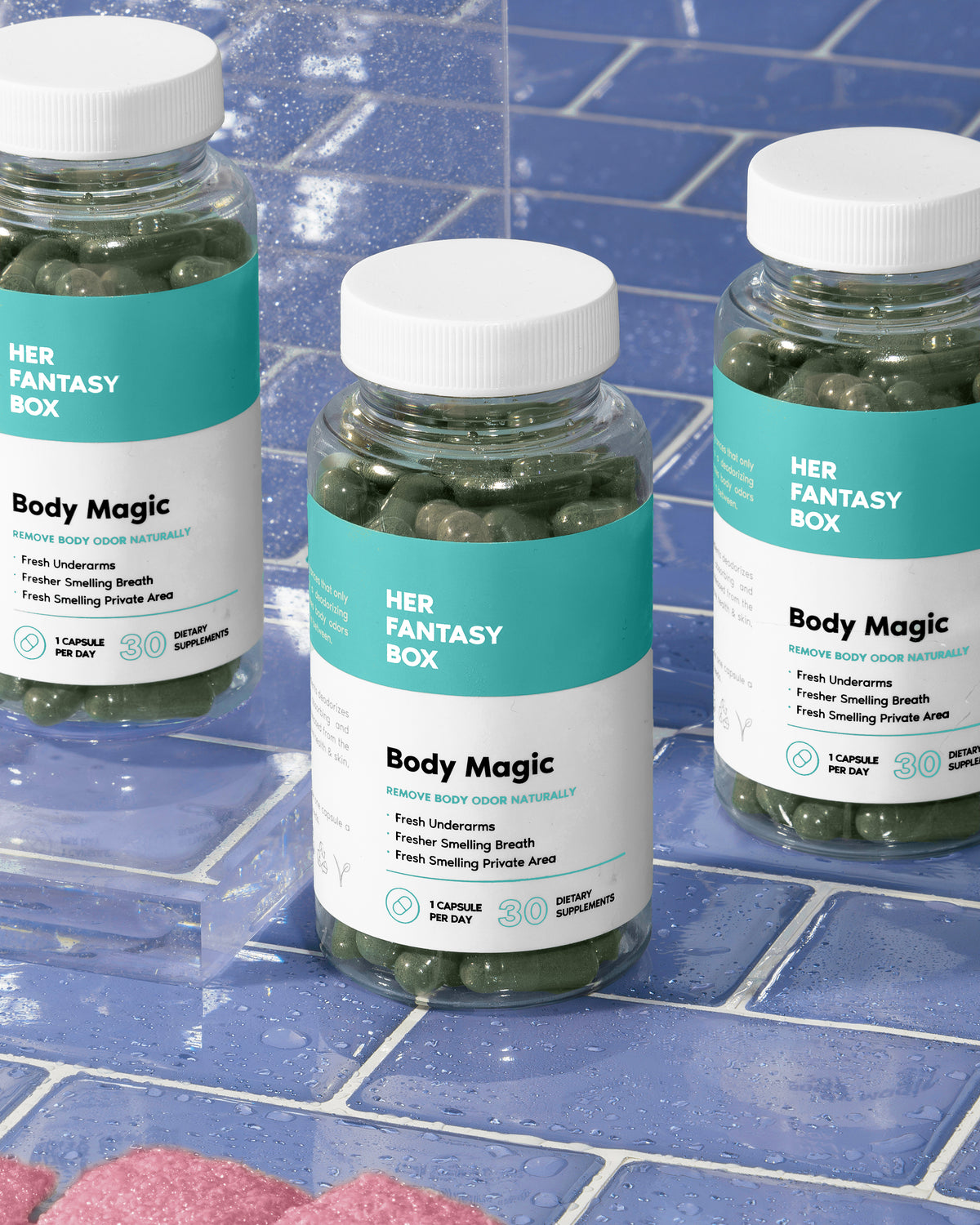 Three bottles of Her Fantasy Box Body Magic dietary supplements for natural body odor control on a blue tiled surface.