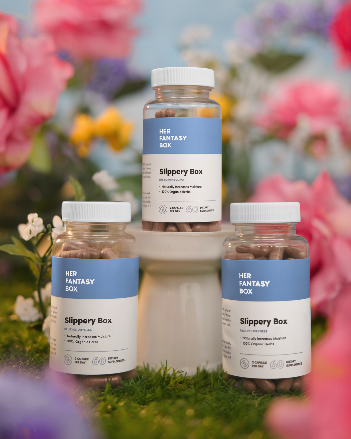 Three bottles of Slippery Box Moisture Capsules set against a floral background, with each bottle labeled clearly.
