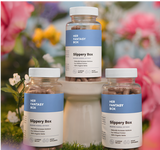 Three bottles of 'Her Fantasy Box Slippery Box' products with a floral background.