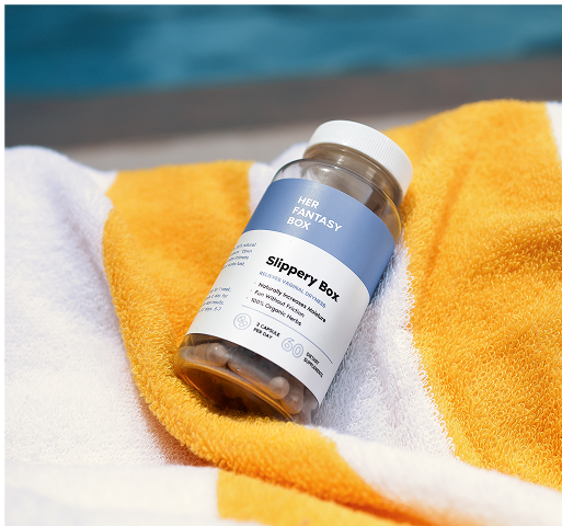 Bottle labeled 'Slippery Box' on a yellow and white towel with a blurred blue background