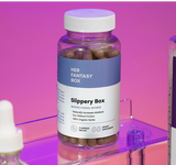 Bottle labeled 'Her Fantasy Box Slippery Box' on a pink background