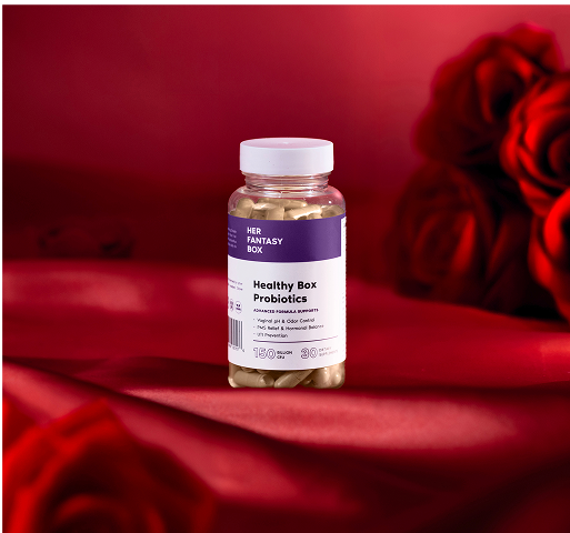 Bottle of 'Her Fantasy' healthy box probiotics on a red surface with roses.
