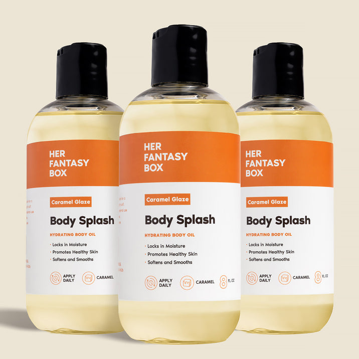 Three bottles of Her Fantasy Box Caramel Glaze Body Splash hydrating body oil displayed together on neutral background