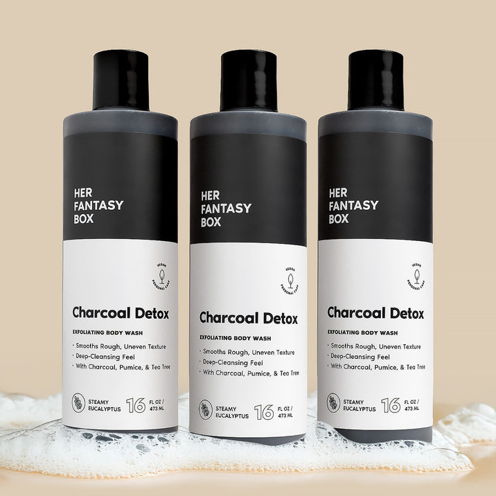 Three bottles of Her Fantasy Box Charcoal Detox Steamy Eucalyptus exfoliating body wash 16 fl oz displayed together on neutral background with lather
