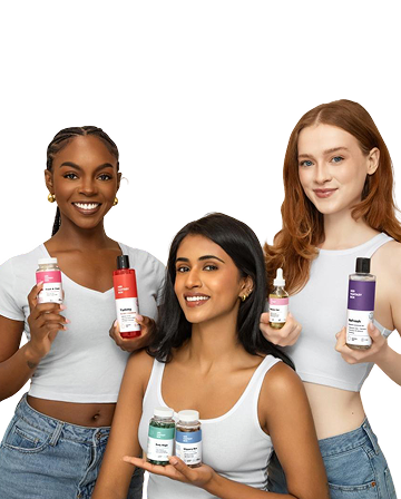 Three women holding various bottles of skincare products against a transparent background
