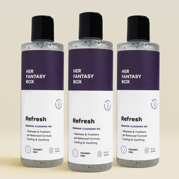 Three bottles of 'HER FANTASY BOX' Refresh Feminine Cleansing Gel on a beige background
