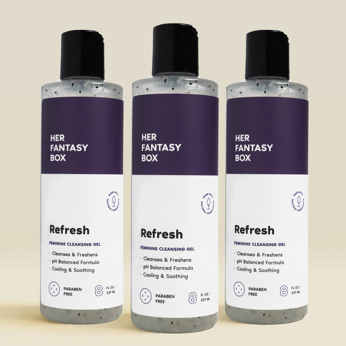 Three bottles of 'HER FANTASY BOX Refresh' feminine cleansing gel on a beige background