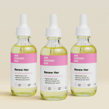 Three bottles of 'Renew Her' skincare product from 'Her Fantasy Box' on a beige background.
